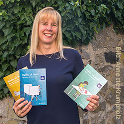 Anne Badman von der KEB Limburg zeigt zwei Broschüren in leicht verständlicher Sprache.